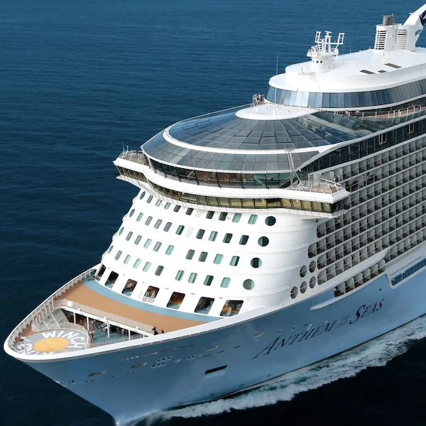 royal caribbean's "anthem of the seas" sailing at daytime. image displays front of ship and helpad