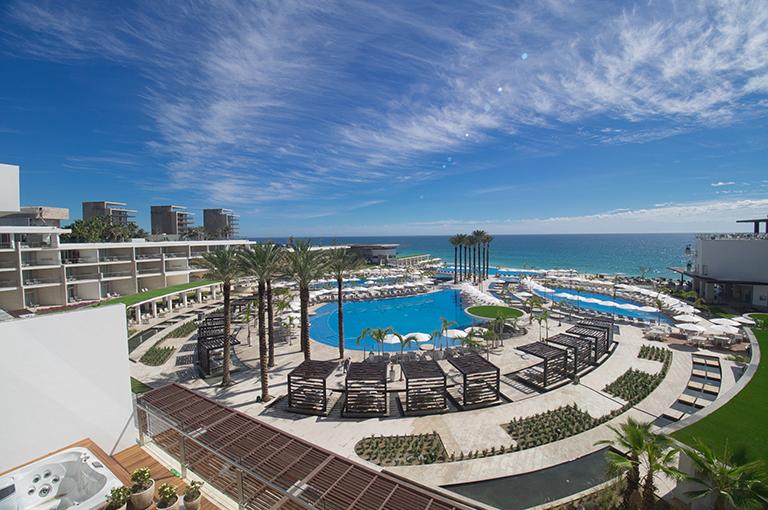 aerial view of resort with pool overlooking the ocean. this image is used to promote all-inclusive resort deals for teachers